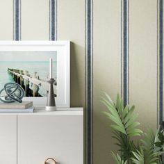 a white cabinet sitting in front of a wall with a painting on top of it