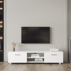 a flat screen tv sitting on top of a white entertainment center in a living room