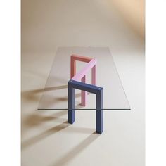 a glass table topped with a pink and blue square shaped object on top of it