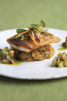 a white plate topped with fish and vegetables