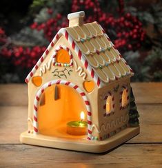 a small gingerbread house candle holder on a table