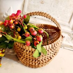 a basket filled with lots of flowers on top of a white counter next to a wall