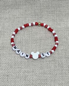 a red and white beaded bracelet with an i love santa written on the clasp