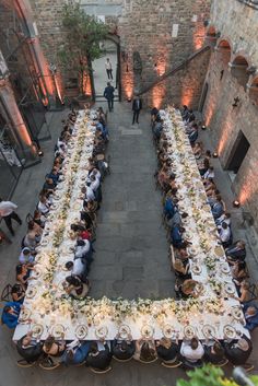 an aerial view of a long table with people sitting at it