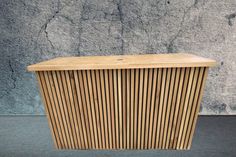 a wooden cabinet sitting in front of a concrete wall