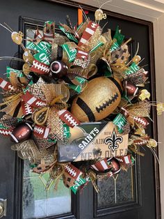 a football wreath is hanging on the front door, decorated with new orleans saints ornaments