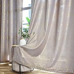 the curtain is open in front of a window with potted plants on top of it