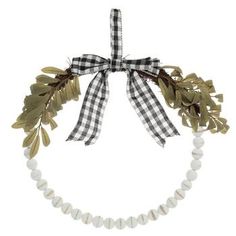 a white and black necklace with leaves on the front, tied in a ribbon around it