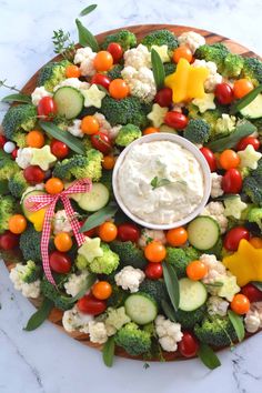 a platter filled with vegetables and dip on top of the words holiday vegetable wreath