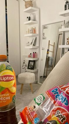 a bottle of lipton sitting on top of a couch next to some snacks and drinks