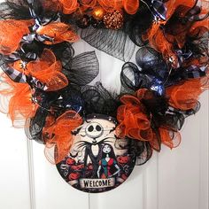 a halloween wreath with an image of skeletons and pumpkins on it that says welcome