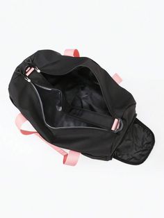 an empty black bag with pink straps on the bottom and inside, sitting on a white surface