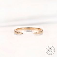 an open gold ring with the word onion written in white lettering on it's side