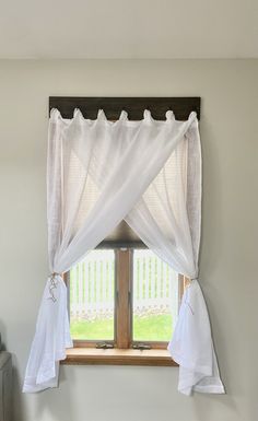 a window with white curtains hanging over it