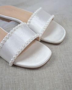 "Classic slide flat sandals combined with radiant rhinestones is perfect to create a statement for casual and dressy look. Simple and easy wear for brides, bridesmaids and wedding parties. DETAILS: COLORS AVAILABLE: Ivory & White UPPER: Synthetic upper and lining MATERIALS: Mandmade outsole STYLE NAME: EVELYN Not sure of which size to purchase? Shoes measurements are as follow: (Please note measurements taken the length of inside of shoe from toe to heel) Size 5.5 - 9.25\" Size 6 - 9.40\" Si Cute White Slip-on Sandals, Elegant White Slip-on Sandals, Classic Wedding Sandals With 4-inch Heel, White Slip-on Wedding Flats, Elegant Pearl-embellished Open Toe Sandals, Bridesmaid Sandals, Bridal Flats, Pointy Toe Flats, Bridal Sandals