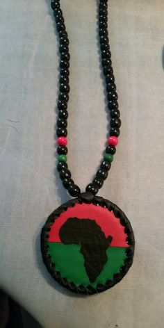 a black beaded necklace with a red, green and blue design on it's center