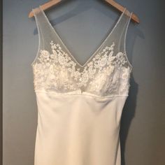 a white wedding dress hanging on a hanger