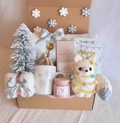 a teddy bear sitting in a gift box with other christmas items and decorations around it