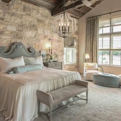 a bedroom with a large bed and chandelier hanging from the ceiling