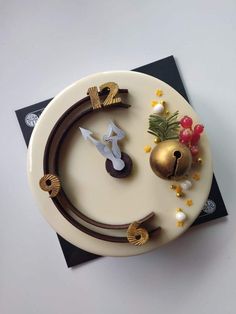 a cake with decorations on top of it sitting on a white plate next to a black napkin