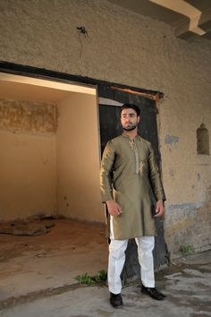 A unique dhani-colored silk kurta and plain cotton silk pajama with gold embroidery and motifs on the placket. Model wears Small/Medium. Traditional Slub Silk Kurta With Dabka Work, Diwali Slub Silk Kurta With Dabka Work, Eid Cotton Silk Bandhgala With Dabka Work, Traditional Drape Kurta With Dabka Work In Cotton Silk, Slub Silk Kurta With Gota Work For Eid, Cotton Silk Kurta With Dabka Work In Traditional Drape, Tussar Silk Kurta With Resham Embroidery For Eid, Eid Tussar Silk Kurta With Resham Embroidery, Traditional Cotton Silk Sherwani With Gota Work