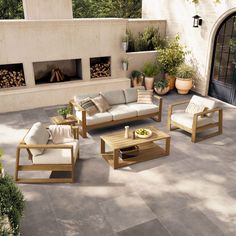 an outdoor living area with couches, tables and potted plants on the patio