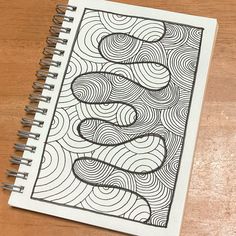 a spiral notebook with an abstract drawing on it