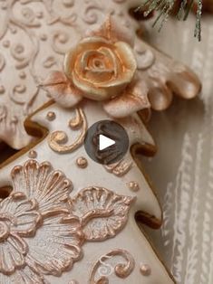 a decorated gingerbread with an ornament on it's side and a pine tree in the background