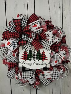 a red and black christmas wreath with trees on it