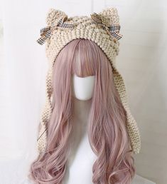 a wig with long pink hair wearing a knitted cat hat on top of a mannequin's head