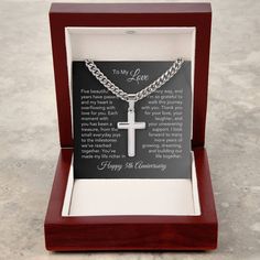 a wooden box with a silver cross and poem in the middle on it's side