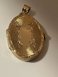 This hand-made oval locket is as sentimental and unique as it gets. It is a perfect Mother's Day present. It is made of 14 karat gold. It is both beautiful and functional. Most lockets can hold 2 pictures but this one can hold 4 special photos close to your, or your loved one's heart! The photos are easy to slip through slots at top of locket. It is hard to match the workmanship of this locket and it's engraving. It was crafted by a very talented jeweler in the NYC jewelry district between 1970 - 1980. Lockets are his legacy and his remaining inventory is being sold on this site. Most are one of a kind and will not be available after it is sold. The best jewelers are in awe of the workmanship and you will always get compliments. This precious locket and can easily become a heirloom that ca Nyc Jewelry, Oval Locket, Athena Goddess, Mothers Day Presents, Pocket Watches, Heart Locket, Gold Pendant, Locket, Jewelry Necklace Pendant