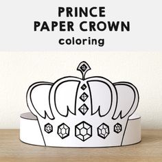 a paper crown sitting on top of a wooden table next to a white sign that says, prince paper crown coloring