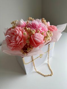 a bouquet of pink flowers in a white box