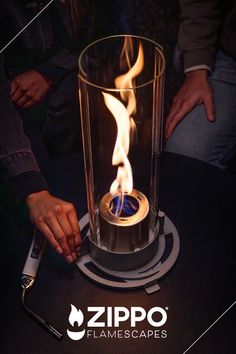 a person holding a lighter in front of a glass container with flames on it and the words zippo flame escapes