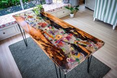 a wooden table sitting in the middle of a living room next to a window with curtains