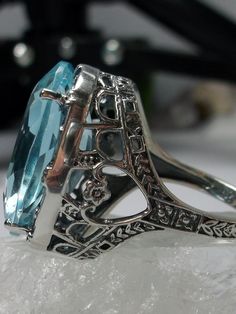 24ct. Simulated Aquamarine Sterling Silver RingOval Beast Design#D76 This is a new beautiful Victorian reproduction ring cast in solid sterling silver. The gorgeous filigree ring is set with a huge approximately 24 carat simulated blue aquamarine gemstone. The stunning gem is 17mm (11/16") wide x 23mm(15/16") long. The ring is 12mm off the finger. The inside of the band is marked 925 for sterling silver. Notice the craftmanship of the sterling silver setting. The large stone is accented by the b Beast Design, Aquamarine Ring, Aquamarine Rings, Filigree Ring, Aquamarine Gemstone, Victorian Jewelry, Aquamarine Blue, Engraved Items, Jewelry Ring