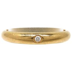 a yellow gold ring with a diamond in the center and a small round stone at the bottom