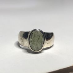 This genuine moldavite ring weighs 6.7 grams and measures to a US size 8 1/4. This rare stone sits in all sterling silver and a raw cut. Our Moldavite is guaranteed 100% genuine from the Czech Republic. Moldavite comes from a meteor collision with Earth almost 15 million years ago. Found only in the Czech Republic these green Gems are one of the most rare minerals on Earth. This tektite is composed of natural glass and is created when a meteorite collides with earth resulting in this green speci Handmade Oval Emerald Ring, Modernist Oval Gemstone Rings, Modern Oval Silver Gemstones, Modernist Oval Sterling Silver Ring, Oval Gemstone Rings In Modernist Style, Modern Jewelry With Large Oval Stone, Handmade Modern Oval Moonstone Ring, Modern Handmade Oval Moonstone Ring, Modern Oval Sterling Silver Gemstones