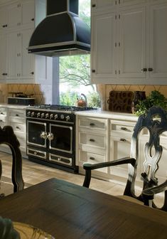 a kitchen with an oven, stove and dining room table