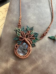 the necklace is made with wire and bead work on top of a piece of fabric