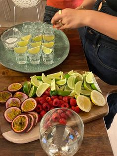 a wooden table topped with fruit and veggies on top of a cutting board