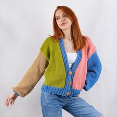 a woman with red hair wearing a multicolored cardigan