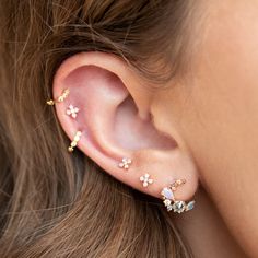 a close up of a person's ear with three small flowers attached to it