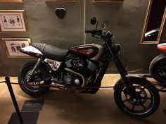 a motorcycle is on display in a room with framed pictures and other things around it