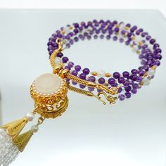 This beautiful necklace set features a multi-style beaded amethyst necklace with a white jade and zircon tassel pendant. The necklace is made up of 81 primary gemstones, with every 9 gemstones grouped and connected by spacer gemstones. The pendant can be detached from the necklace and replaced with any pendant you like, and the necklace can also be worn as a glasses chain. The ancient Chinese believed that the number 9 symbolized eternity, and that surviving 81 tribulations could help a person r Elegant 108 Beads Jewelry Gift, Elegant Necklace With 108 Beads For Gift, Elegant Round Jewelry With 108 Beads, Luxury Purple Jewelry With Round Beads, Elegant Necklace With 108 Beads Pendant, Elegant Natural Stones Jewelry For Meditation, Elegant Natural Stone Jewelry For Meditation, Luxury Amethyst Gemstone Beads Jewelry, Elegant Hand-strung Multi-strand Jewelry