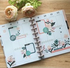 an open planner with flowers on top of it