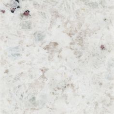 a white marble counter top with black and red dots on the bottom, in an area that looks like it has been scratched or stained