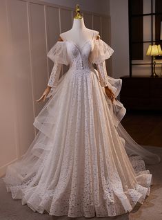 a white wedding dress on display in a room