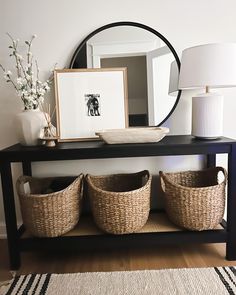 a black table with baskets under a mirror